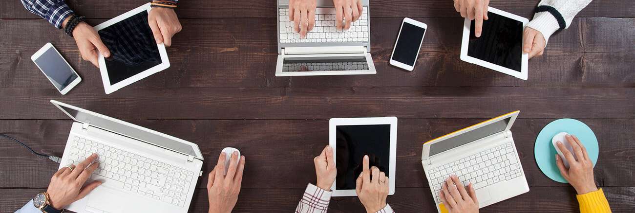 table of coworkers on their laptops and tablets