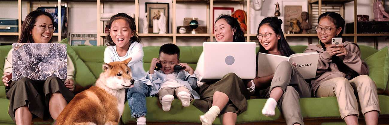 Family on sofa with multiple phone and devices